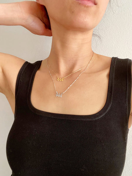 There are 2 of 444 necklaces on the model. The top one is a gold filled 444 Angel number necklace that is made of gold filled material. It's layered with a sterling silver 444 Angel number necklace that is 18" long.