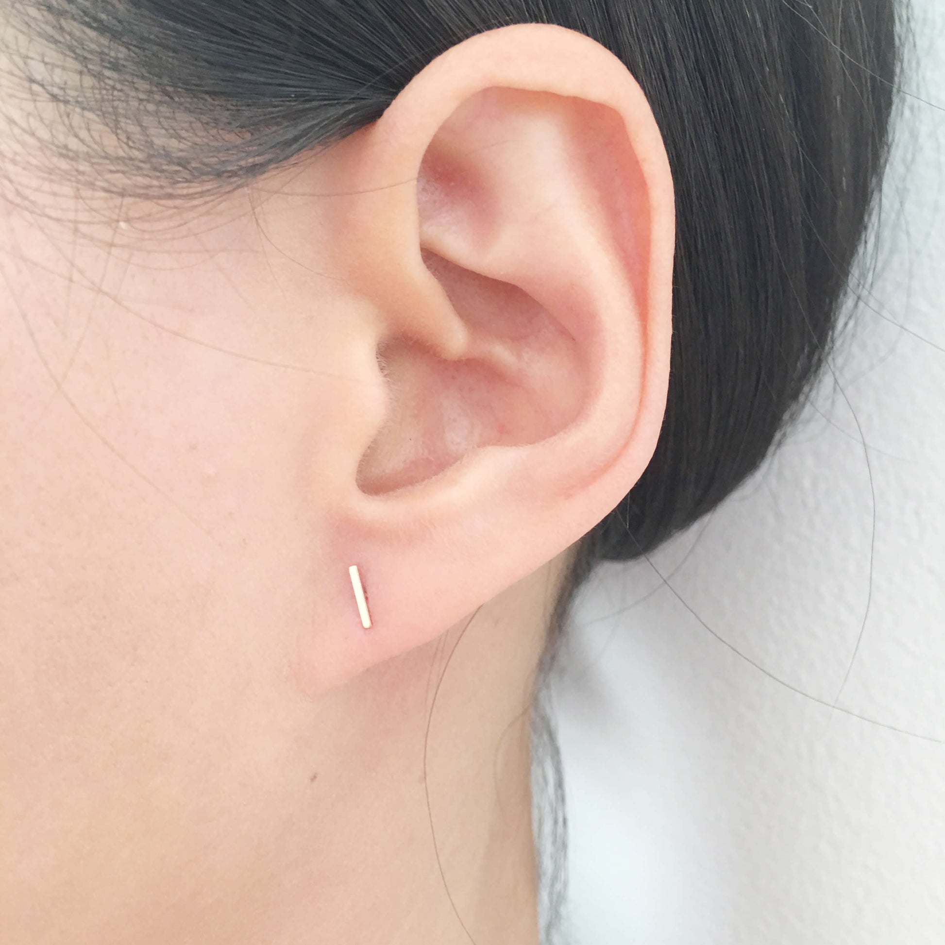This tiny bar stud earring is made of solid 14k gold. for pierced ear. Since it small and dainty you can layer it with other gold stud earrings you have multiple ear pierced.