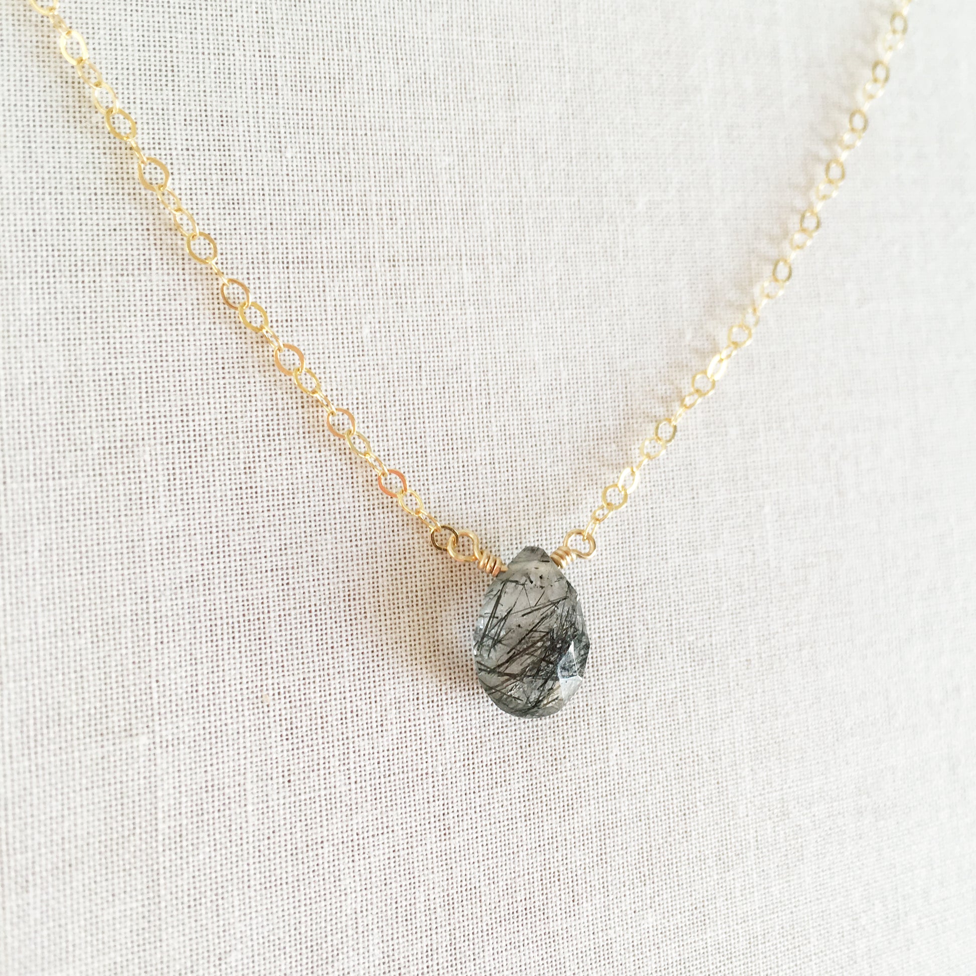 this black rutilated quartz necklace is made with a single gemstone called black rutilated quartz.  This healing quartz necklace has unique black lines through it caused by naturally occurring minerals inside the quartz stone.