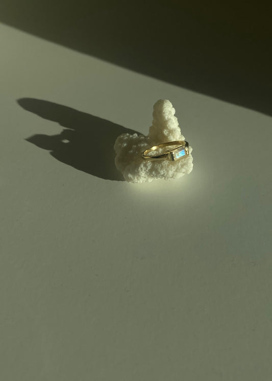 This is a gold moonstone ring that is setting in Baguette style. 