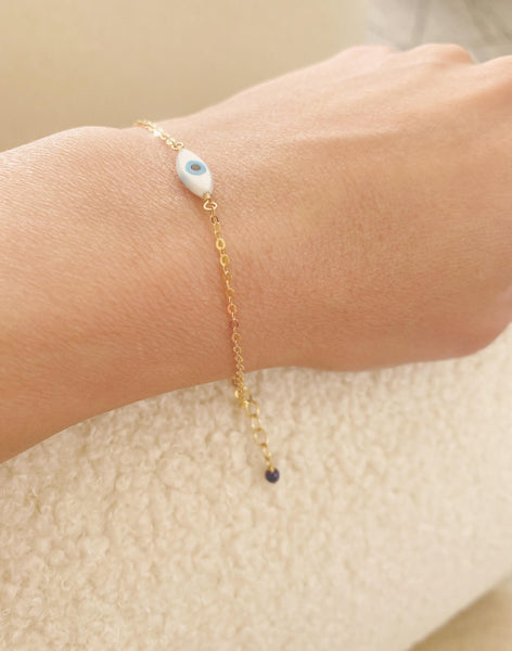This is a cute evil eye bracelet is made of gold filled chain with mother of pearl evil eye charm with lapis lazuli bead. 