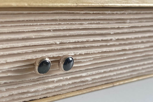 Close up of a pair of Hematite stud earrings made in sterling silver with genuine Hematite gemstones.