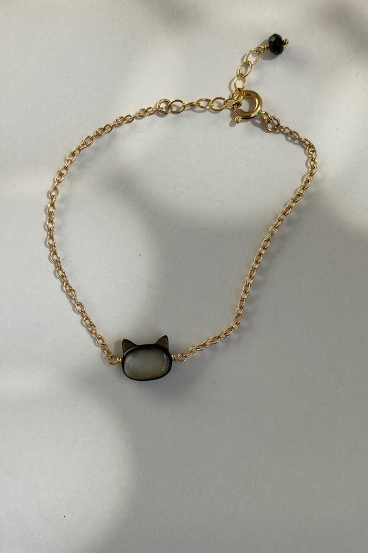 This is a black cat bracelet that is made of gold filled chain and black mother of pearl cat charm with black tourmaline bead at the end of the extender. 