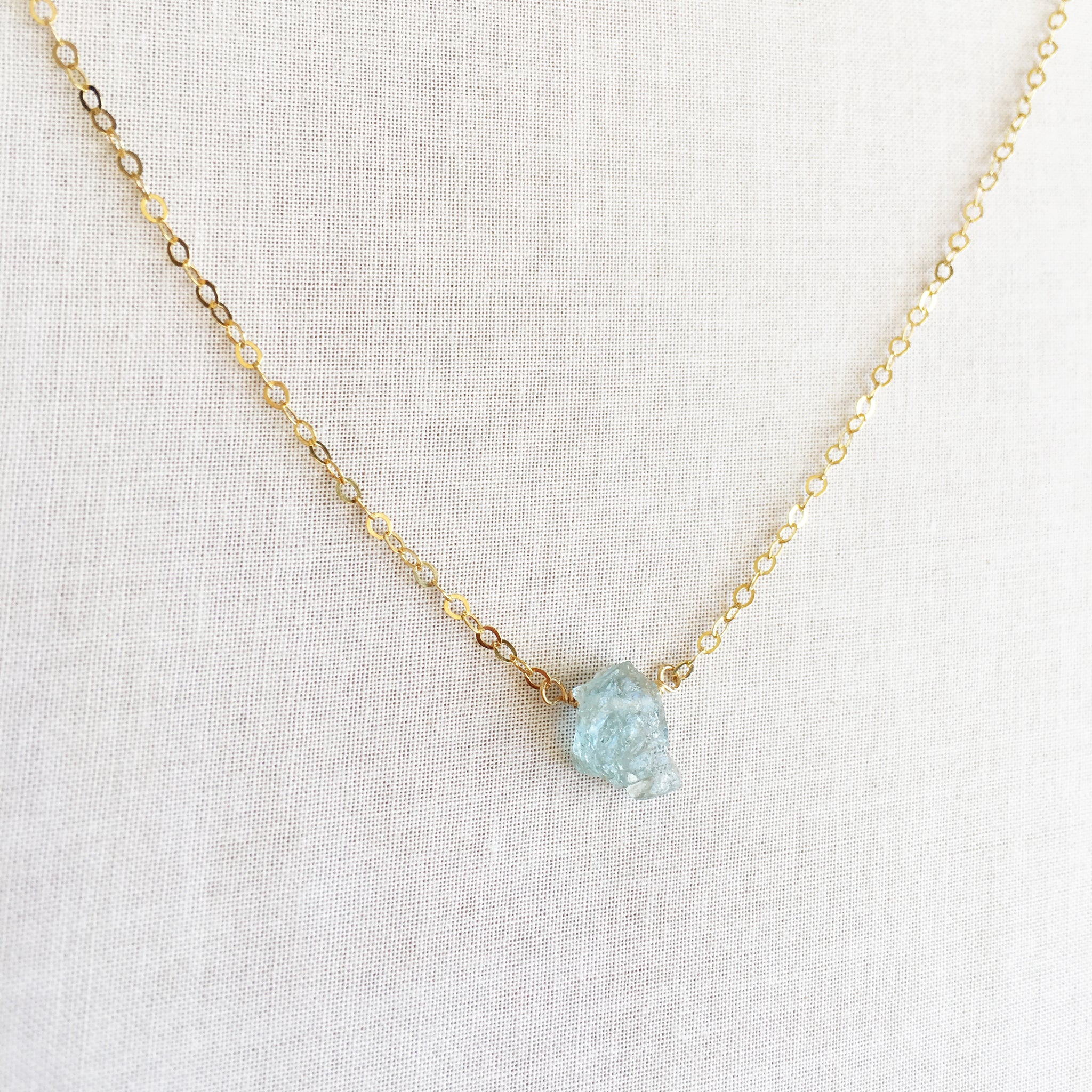 This is a Raw Aquamarine necklace that's made of 14k gold chain and raw Aquamarine. 