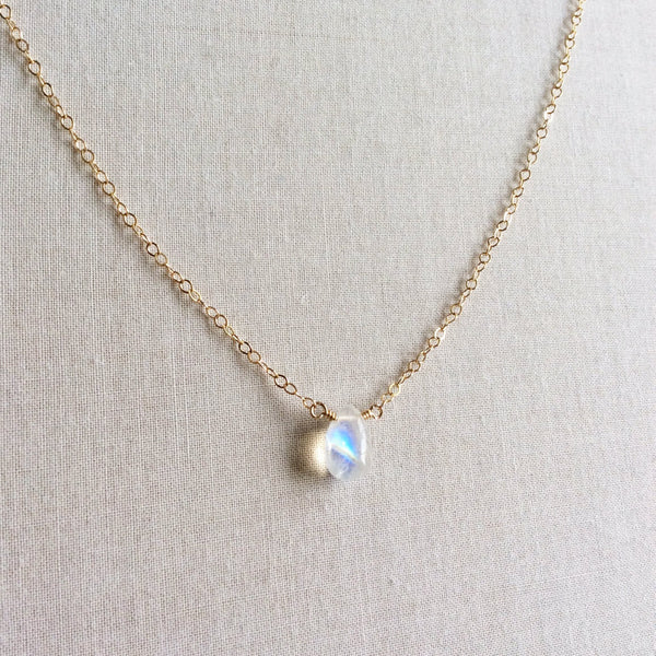 The dainty moonstone necklace that we make features a single genuine moonstone and is attached to a 14k gold, gold fill or sterling silver chain.
