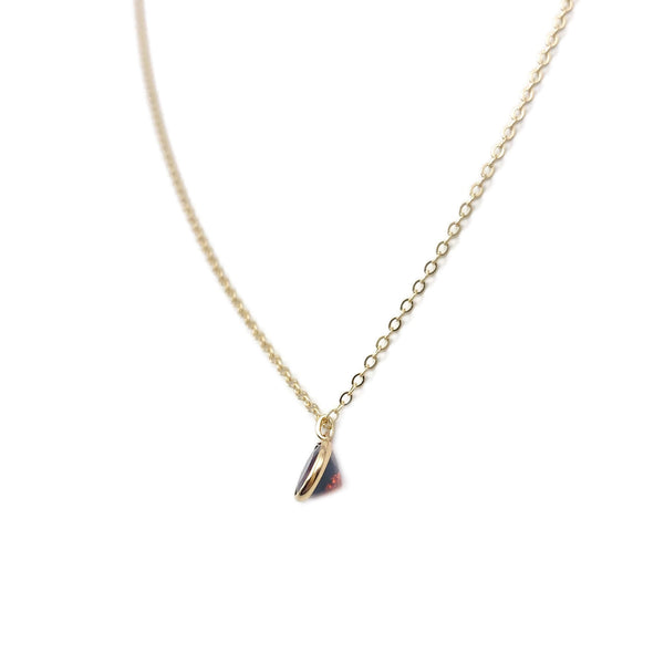 This is a dainty garnet necklace that is January birthstone. The garnet is a diamond cut shape. It's dainty.