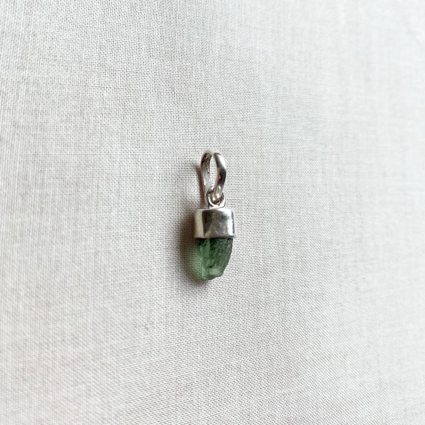 This is a moldavite pendant that is made of genuine Moldavite with sterling silver